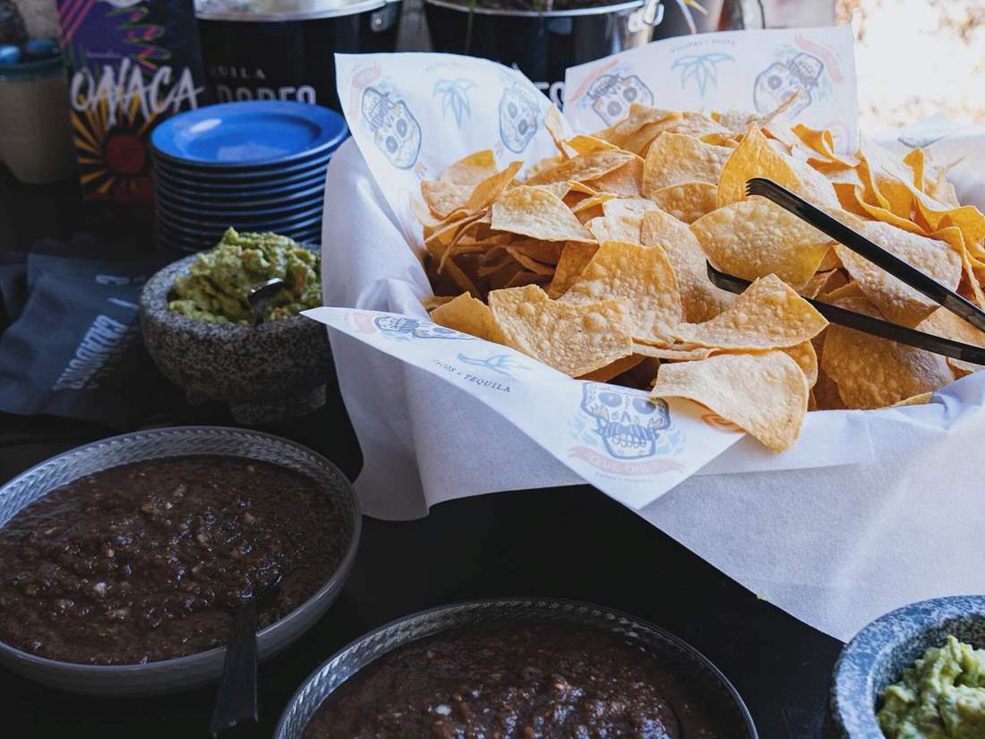Tortilla chips, black bean dips and guacamole setup for a catered event.